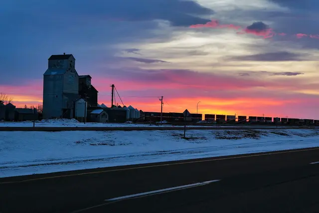 Grain elevator and freight train at sunrise